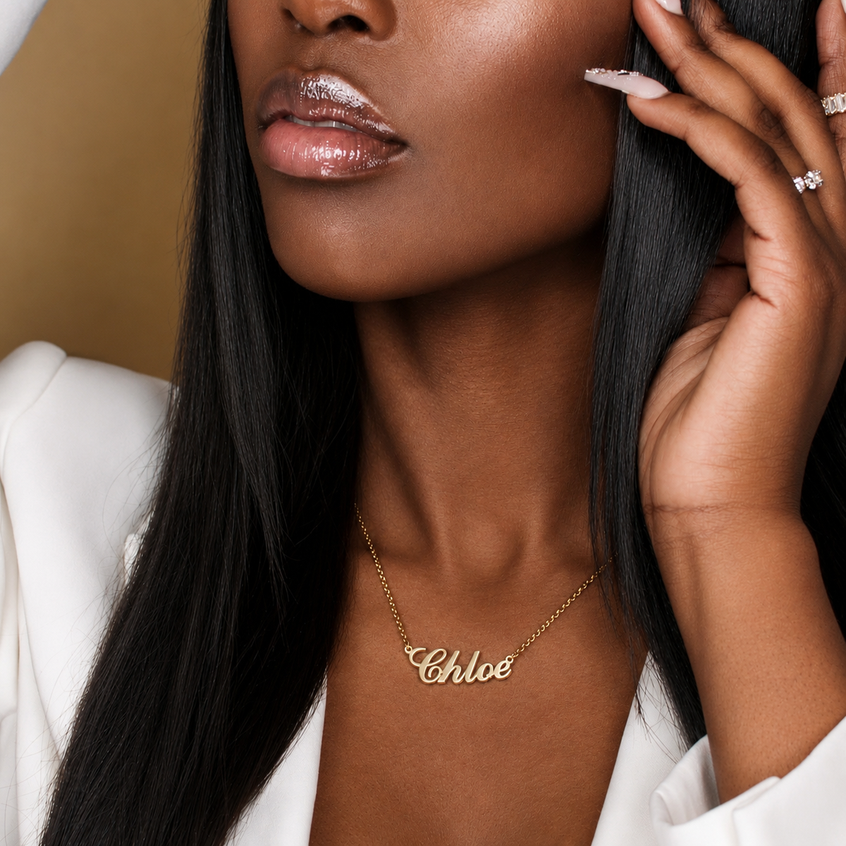 Woman wearing a gold necklace with the name 'Chloe' on a neutral background