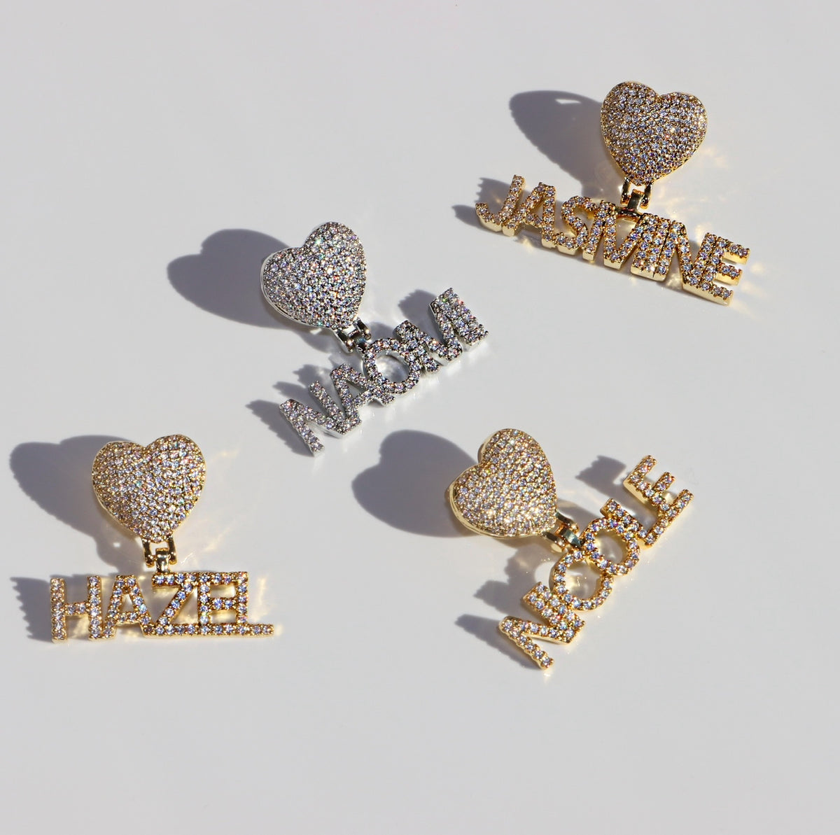 Heart-shaped earrings with personalized name charms on a light background