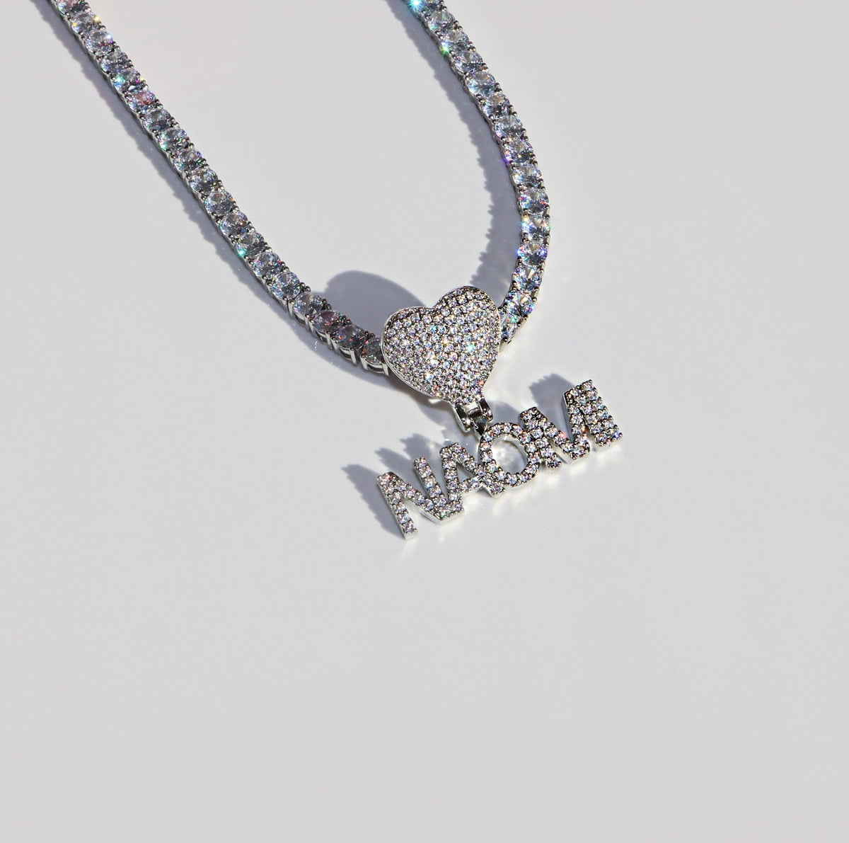 Necklace with heart-shaped and 'LOVE' pendant on a light gray background