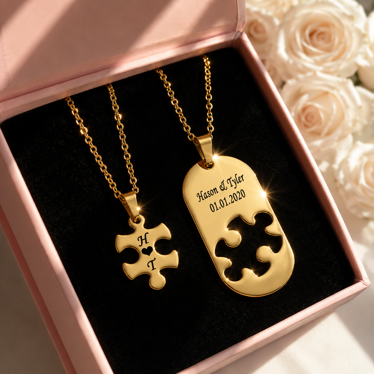 Gold puzzle piece necklaces in a box with roses in the background