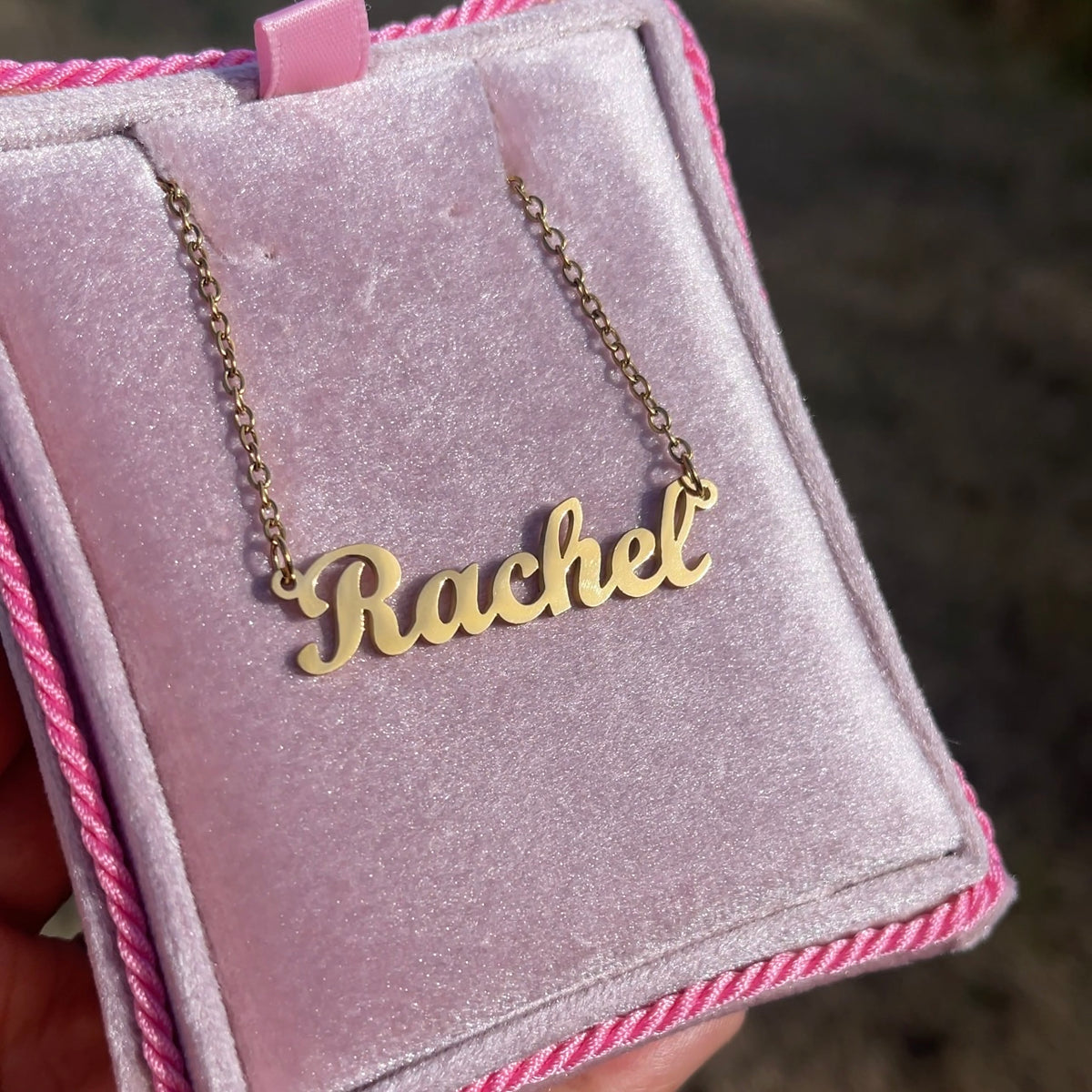 Gold 'Rachel' necklace on a pink velvet box